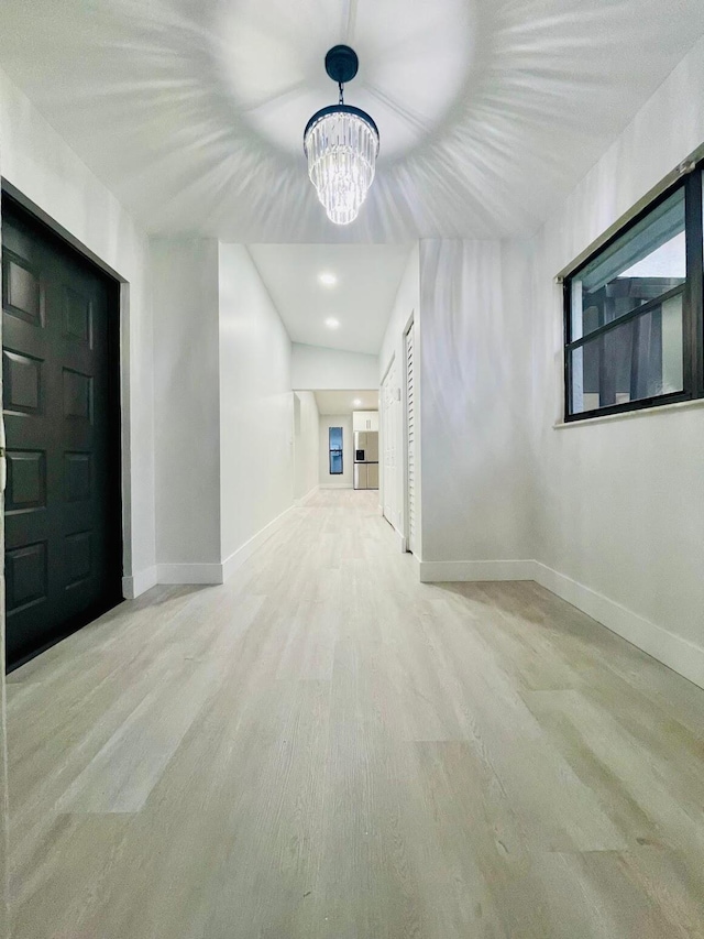 bonus room featuring light hardwood / wood-style floors and a notable chandelier