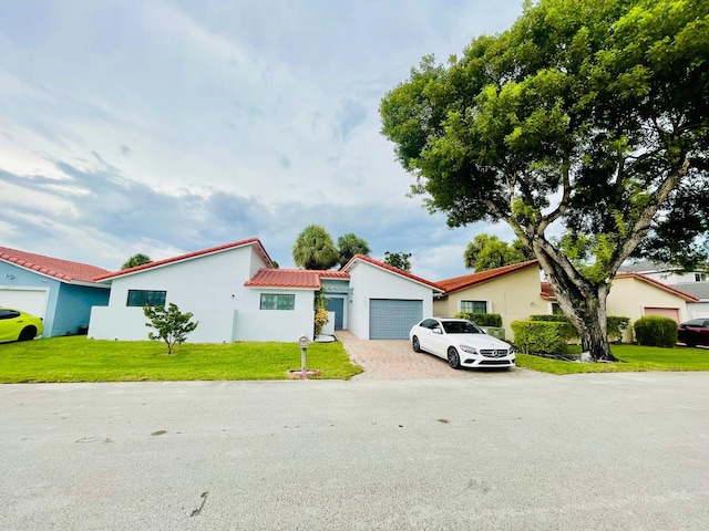 mediterranean / spanish-style home featuring a front yard and a garage