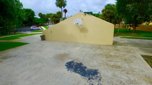 view of side of home featuring basketball hoop