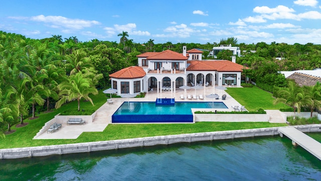 rear view of property with a yard, a patio area, a balcony, and a water view