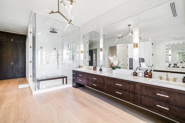 bathroom with a tile shower, vanity, and hardwood / wood-style flooring