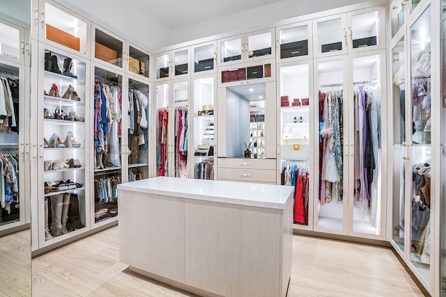 walk in closet with light hardwood / wood-style flooring