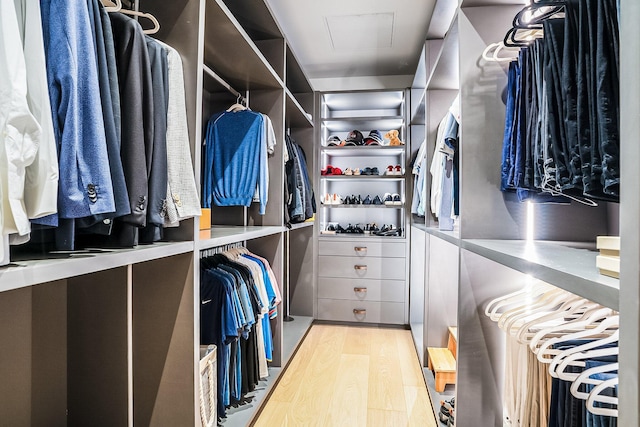 walk in closet with light hardwood / wood-style flooring