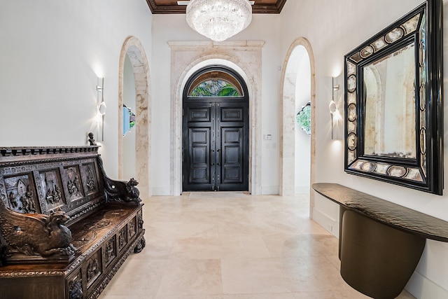 entrance foyer with an inviting chandelier, crown molding, and a healthy amount of sunlight