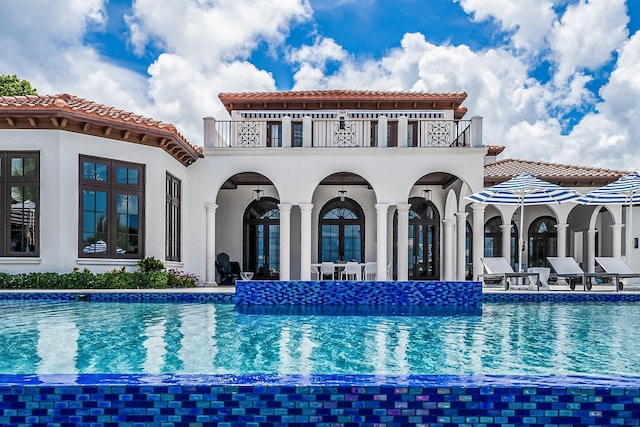 back of house with a patio area, french doors, and a balcony