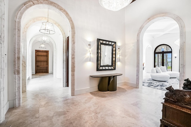 hallway with beamed ceiling, coffered ceiling, and a notable chandelier