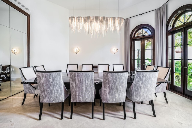 dining area with a high ceiling, a chandelier, and french doors