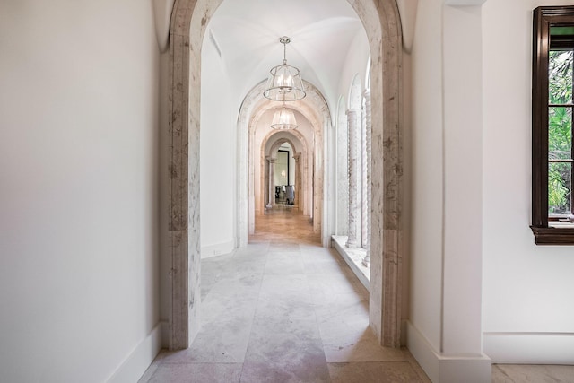 hallway featuring lofted ceiling and a wealth of natural light