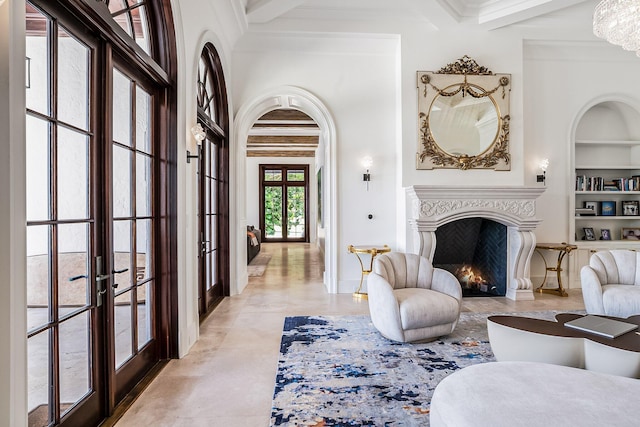 living room featuring french doors, ornamental molding, beam ceiling, and built in shelves