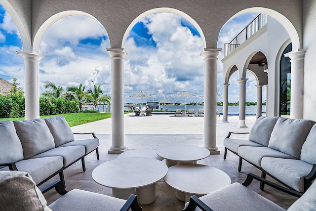 view of patio / terrace with a balcony, a water view, and an outdoor hangout area