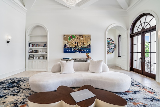 living room featuring built in shelves, coffered ceiling, crown molding, and beamed ceiling