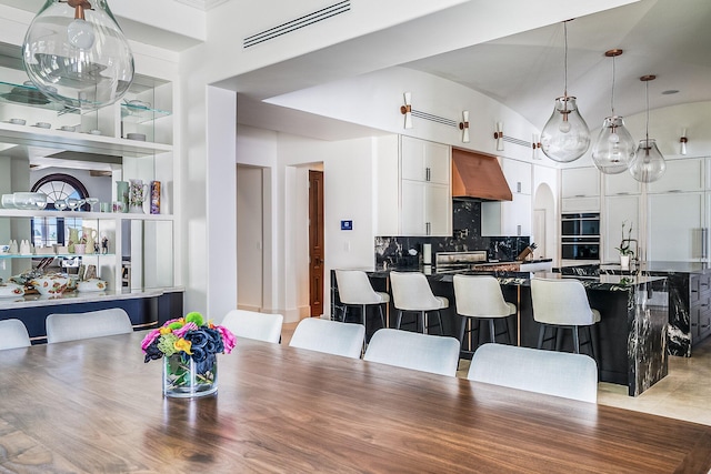 tiled dining space featuring vaulted ceiling