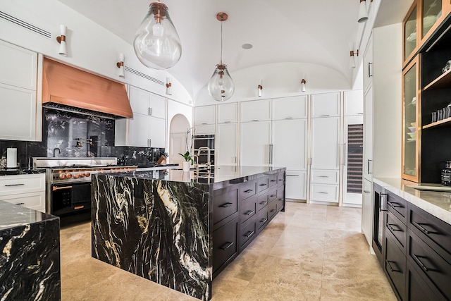 kitchen featuring hanging light fixtures, white cabinets, and dark stone counters