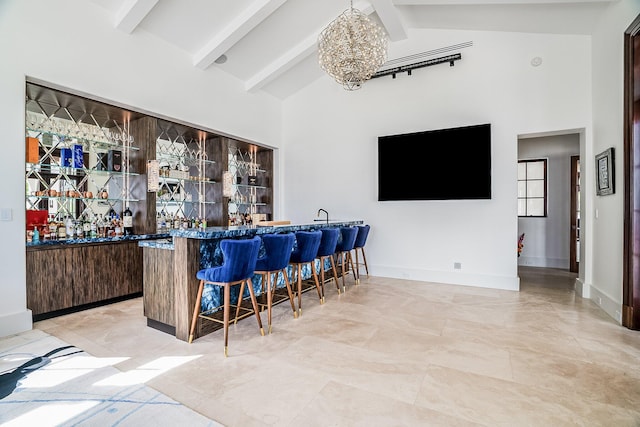 bar with an inviting chandelier, beam ceiling, high vaulted ceiling, and hanging light fixtures