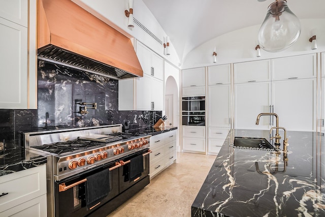 kitchen featuring double oven range, custom exhaust hood, sink, and white cabinets