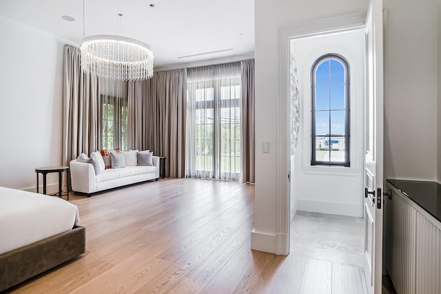 bedroom with ornamental molding, a chandelier, and light wood-type flooring