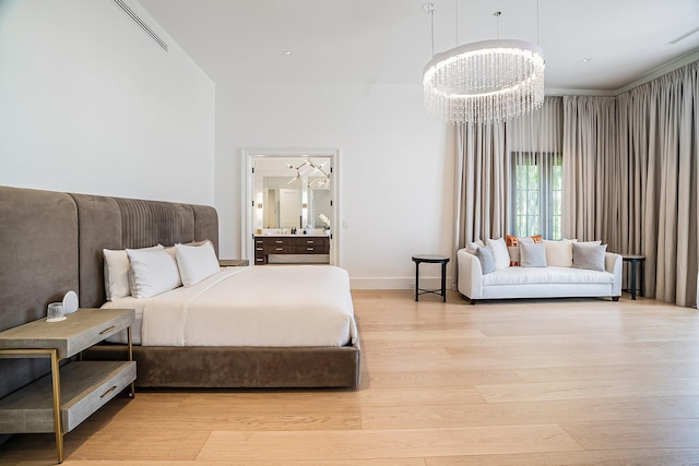 bedroom with a notable chandelier and light hardwood / wood-style floors