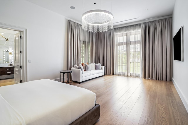 bedroom with light wood-type flooring and an inviting chandelier