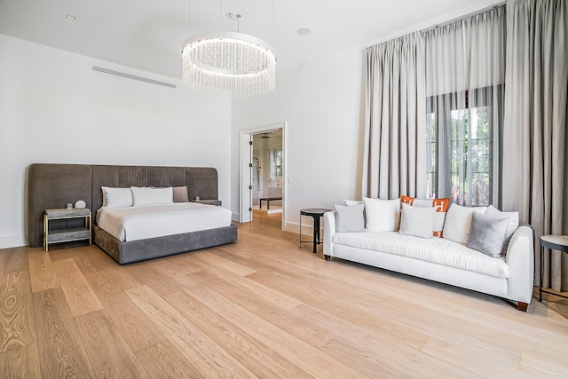 bedroom with an inviting chandelier and light hardwood / wood-style floors