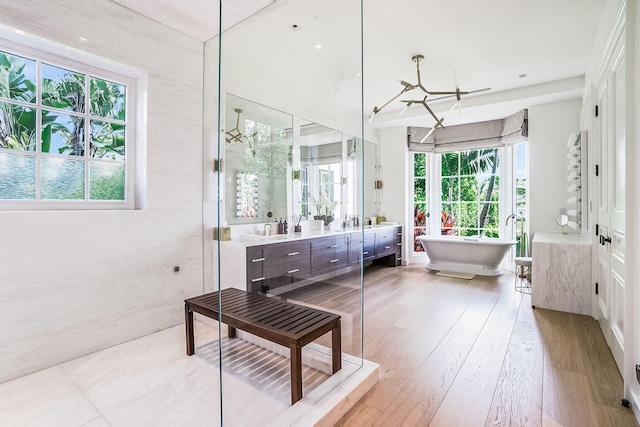 bathroom featuring wood-type flooring, shower with separate bathtub, and vanity