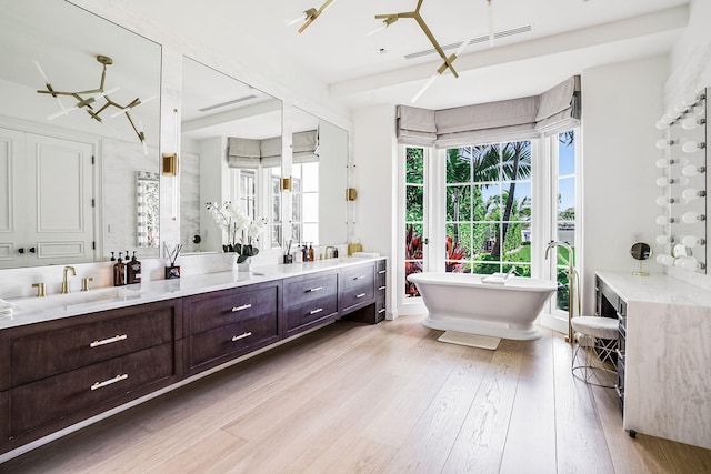 bathroom with vanity, hardwood / wood-style floors, and a bathtub