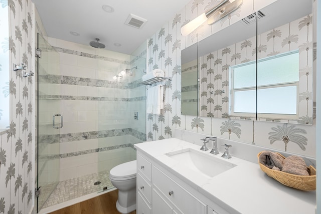 bathroom with toilet, an enclosed shower, vanity, and wood-type flooring