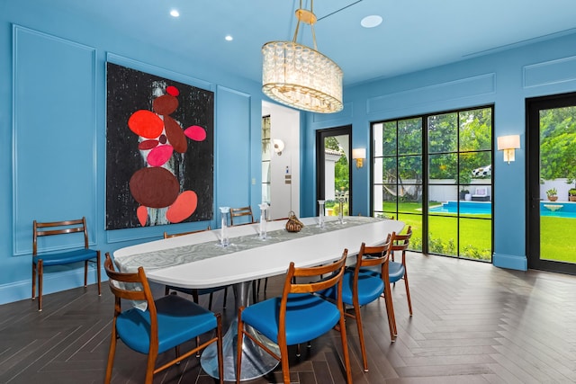 dining room featuring dark parquet floors and a notable chandelier