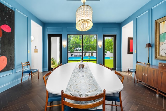 dining room with dark parquet floors and an inviting chandelier