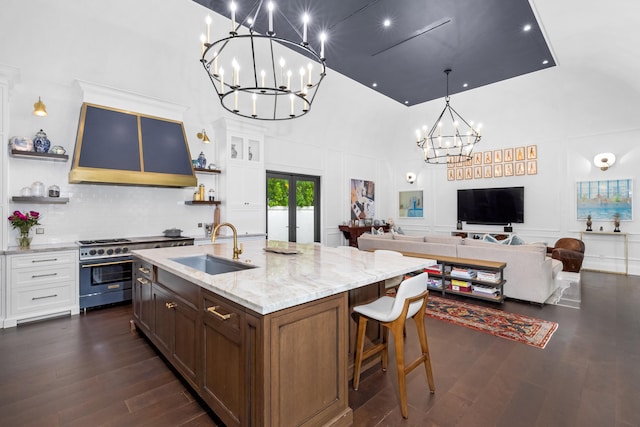 kitchen featuring custom exhaust hood, white cabinetry, dark hardwood / wood-style flooring, sink, and a towering ceiling