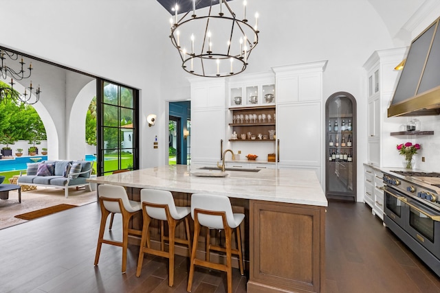 kitchen with dark hardwood / wood-style flooring, range with two ovens, a towering ceiling, and white cabinetry