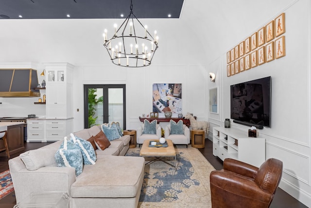 living room with high vaulted ceiling, an inviting chandelier, and dark hardwood / wood-style flooring