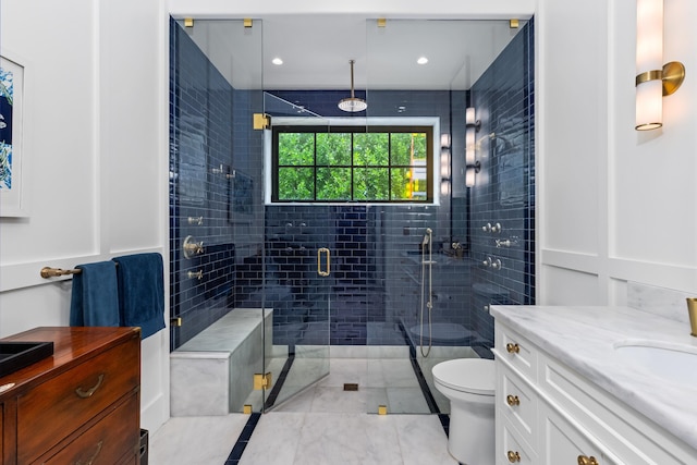 bathroom featuring vanity, toilet, and a shower with door