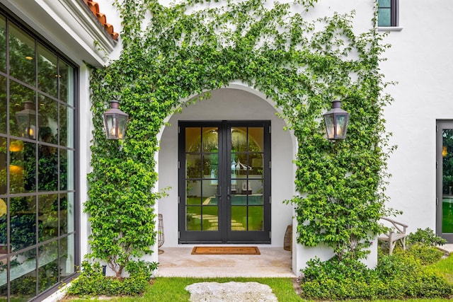 view of exterior entry featuring a patio and french doors