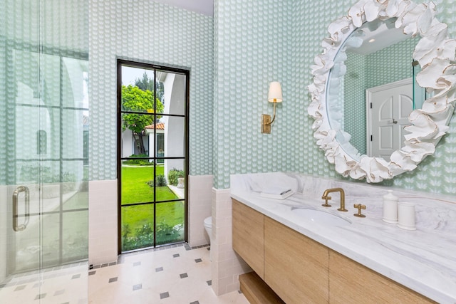 bathroom with toilet, a shower with door, and vanity