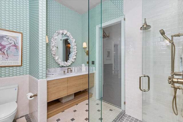 bathroom featuring vanity, hardwood / wood-style floors, walk in shower, tile walls, and toilet