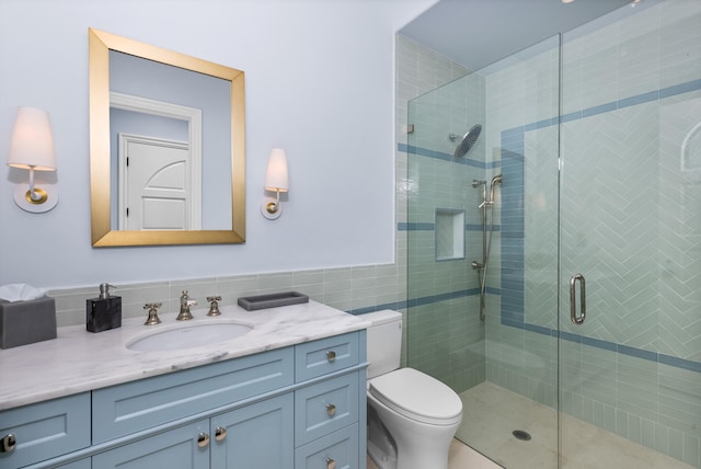 bathroom with walk in shower, toilet, tile walls, tasteful backsplash, and vanity