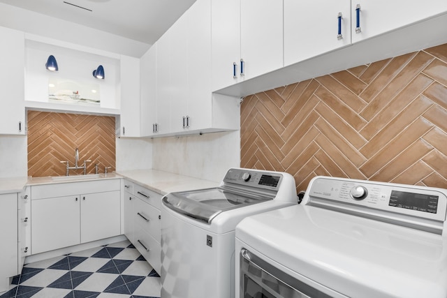 laundry area featuring cabinets, sink, and independent washer and dryer