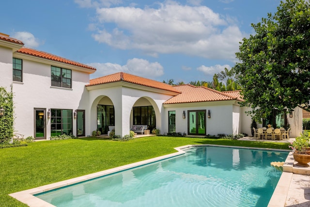 back of house featuring a lawn and a patio