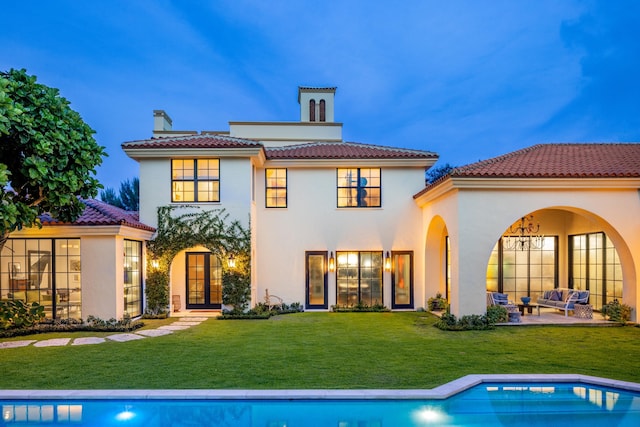 rear view of property with outdoor lounge area, a patio area, and a lawn