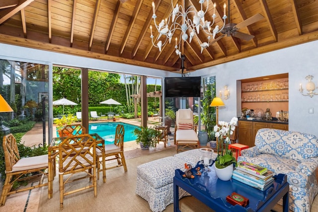 sunroom with lofted ceiling with beams, wood ceiling, and ceiling fan with notable chandelier