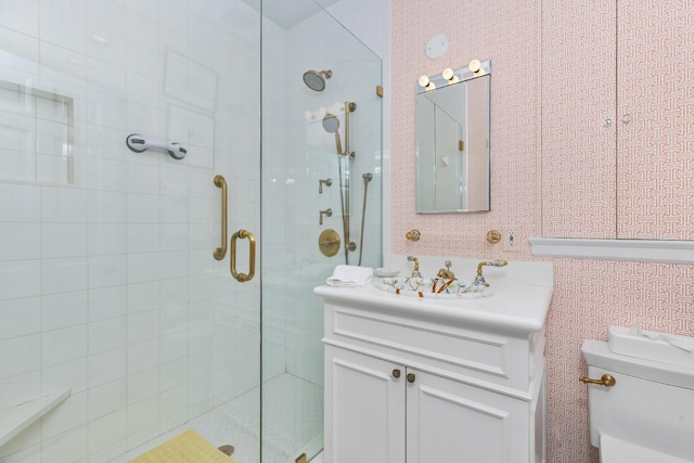 bathroom featuring a shower with door, vanity, and toilet