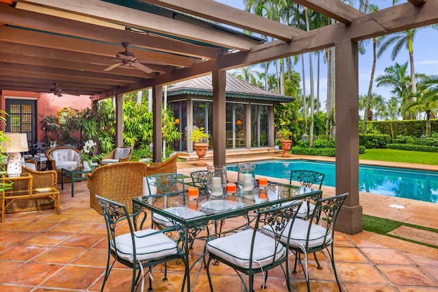 view of pool with a sunroom, ceiling fan, and a patio