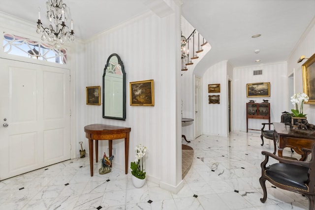 entrance foyer with an inviting chandelier and crown molding