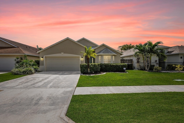 ranch-style house featuring a yard and a garage