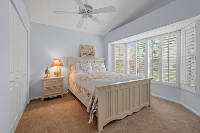 bedroom featuring lofted ceiling, light colored carpet, ceiling fan, and a closet