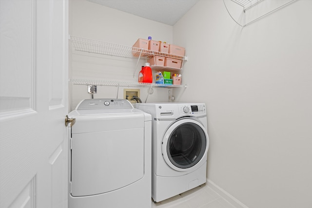 laundry area featuring washing machine and dryer and light tile patterned flooring