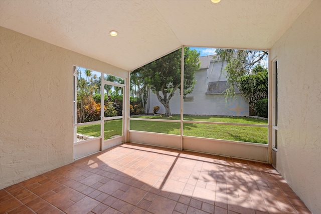 unfurnished sunroom featuring vaulted ceiling