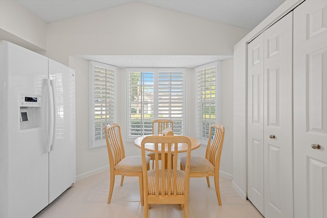 tiled dining room with vaulted ceiling