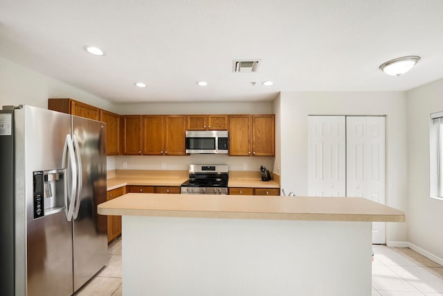 kitchen featuring a kitchen island, stainless steel appliances, and light tile patterned floors