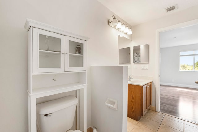 bathroom with vanity, toilet, and hardwood / wood-style floors